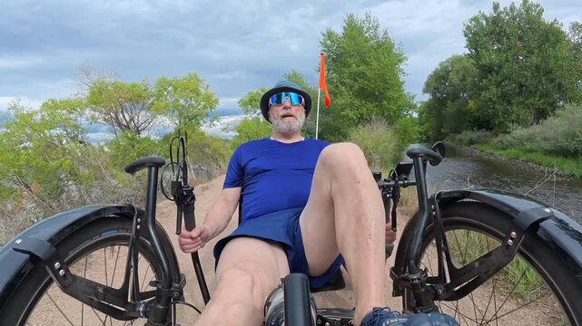 Senior cyclist is riding a full suspension recumbent tricycle on a rough gravel trail in northern Colorado - late summer scenery in Prospect Ponds Natural Area