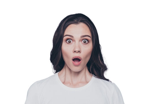 Portrait of attractive pretty charming stylish scared brunette curly-haired girl in casual white t-shirt with staring big eyes and opened mouth, isolated over grey background