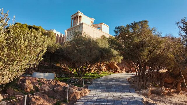Stone pathway winding through olive trees leading up towards the Temple of Athena Nike, Athens, Greece