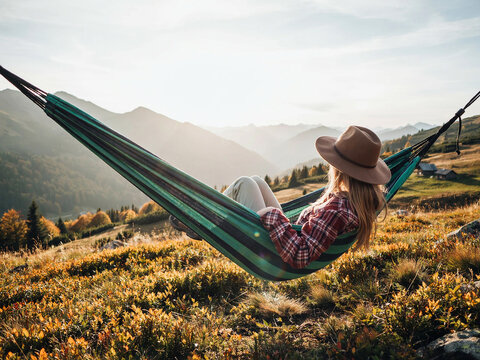 Woman Relaxing in Hammock with Mountain View at Sunset