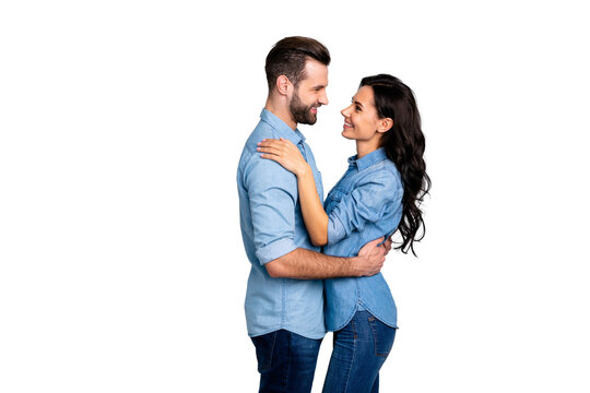 Affection. Profile side view photo of handsome casual spouses looking into eyes satisfied delighted enjoying society dressed in blue denim shirts isolated over argent background