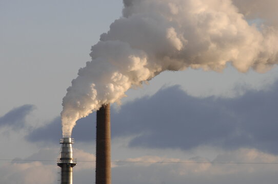 Aus dem Kamin einer Industrieanlage str&ouml;men Abgase, Rauch und Dampf