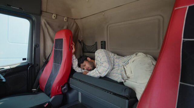 Tired truck driver sleeping inside cabin during rest stop break