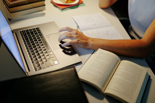 Close up view of a teen student typing on the laptop keyboard.