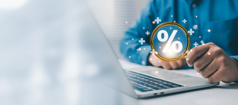 Business finance concept showing a professional using a laptop with a glowing percent symbol, representing discounts, savings, financial offers, online shopping, sales promotion, and digital commerce.