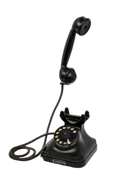 Vintage black rotary telephone with off-hook handset isolated on white back