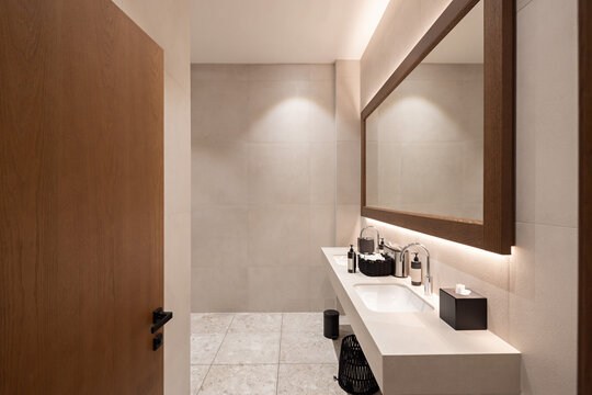 Modern bathroom interior with wooden framed mirror and double sink counter