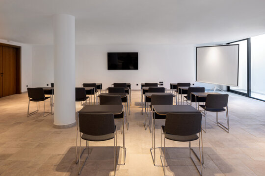 Modern seminar room layout with chairs projector screen and TV