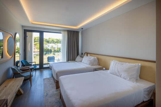 Modern hotel room with twin beds and balcony view