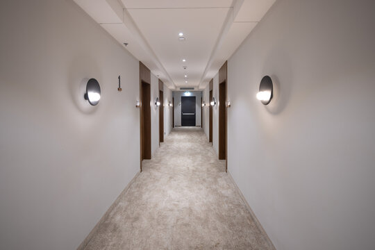 Symmetrical hallway corridor in modern hotel with warm lighting