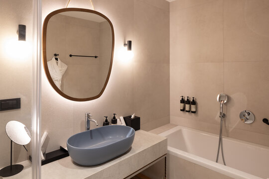 Modern luxury bathroom interior with oval sink mirror and bathtub