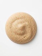 Fototapeta premium Top View of a Circular Dollop of Light Brown Cosmetic Foam or Creamy Mousse Isolated on White Background