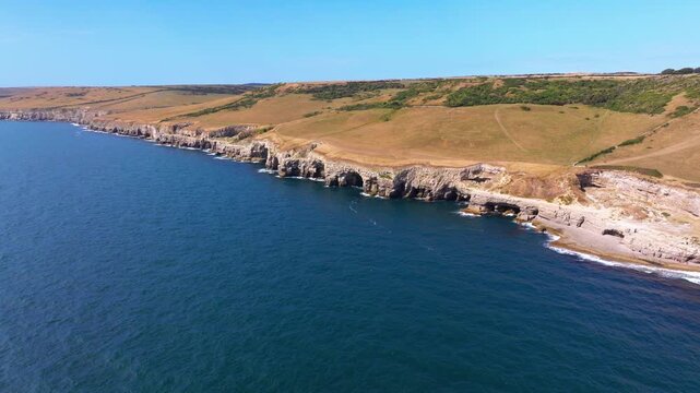 Tracking aerial shot of the Jurassic Coastline and cliffs near Dancing Ledge in Dorset, UK