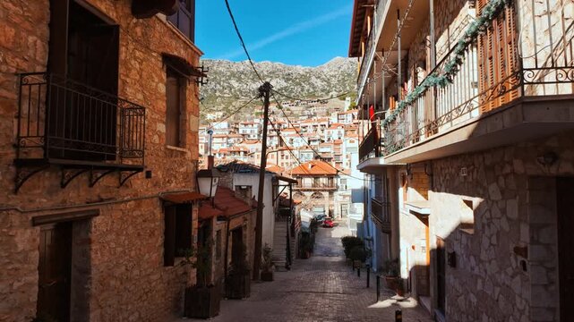 Traditional stone hotels and balconies under a clear sky in the town center of Arachova, Greece