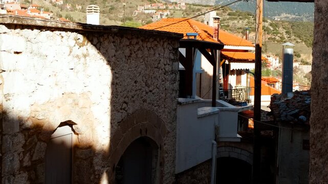 Traditional stone hotels and balconies under a clear sky in the town center of Arachova, Greece
