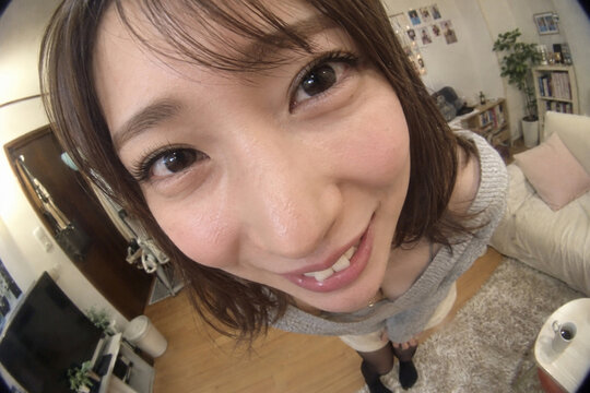 室内で顔を近づけて笑う灰色ニットの女性を魚眼風に捉えた写真