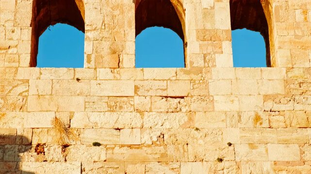 Odeon of Herodes Atticus stone arches in golden light in Athens, Greece