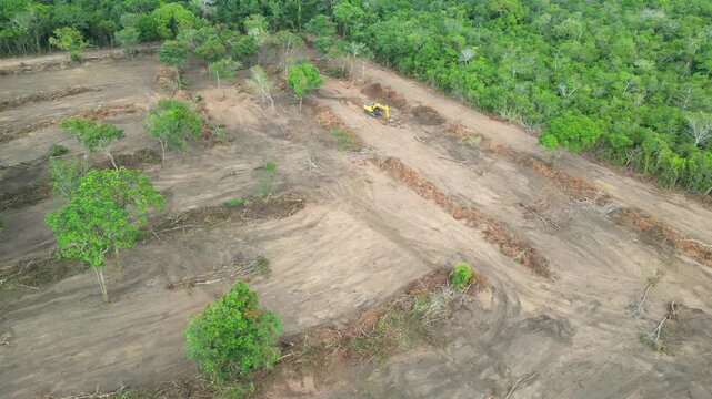 Aerial drone flyover documenting native rainforest being deforested with the use of an excavator in the Brazilian Amazon