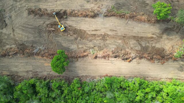 Aerial drone flyover documenting native rainforest being deforested with the use of an excavator in the Brazilian Amazon