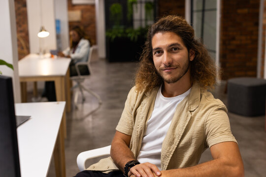 Diverse coworkers working at coworking office on white desks with laptop, lamp, beige overshirt