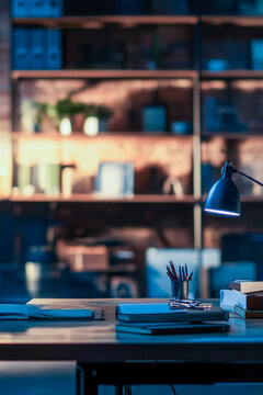 A study desk with a lamp and books, perfect for studying or reading. vertical frame