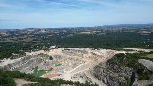 Hingston Down, Cornwall, England: DRONE VIEWS: The drone circles around and behind the granite quarry showing both the stepped quarrying technique and the pools of water mineralised with Arthurite.
