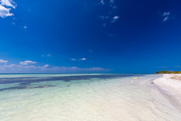 Tropical sandy beach and an exotic view of the Atlantic Ocean against a blue sky with clouds in Cuba, Caribbean – background for projects, wallpaper © anettastar