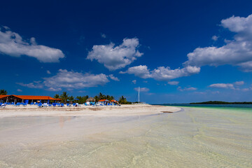 Tropical sandy beach and an exotic view of the Atlantic Ocean against a blue sky with clouds in Cuba, Caribbean – background for projects, wallpaper © anettastar