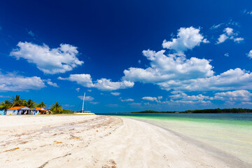 Tropical sandy beach and an exotic view of the Atlantic Ocean against a blue sky with clouds in Cuba, Caribbean – background for projects, wallpaper © anettastar
