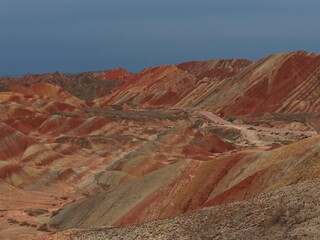 Colorful Zhangye Danxia mountains in Gansu, China, featuring layered rainbow rock formations, dramatic desert scenery and striking geology in a famous Danxia geopark. © JEREMIE