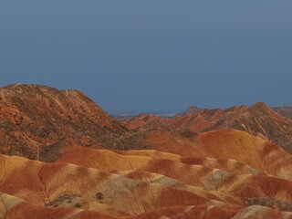 Colorful Zhangye Danxia mountains in Gansu, China, featuring layered rainbow rock formations, dramatic desert scenery and striking geology in a famous Danxia geopark. © JEREMIE