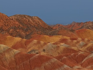 Colorful Zhangye Danxia mountains in Gansu, China, featuring layered rainbow rock formations, dramatic desert scenery and striking geology in a famous Danxia geopark. © JEREMIE
