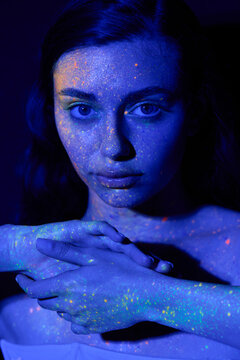 Young woman emulating futuristic beauty with neon inspired art