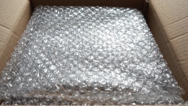 Open cardboard box filled with protective plastic bubble wrap