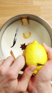 Hands slice lemon peel and drop it into milk mixture. Lesson explains how warm dairy extracts fresh citrus flavour. Students use infused base for custard, pudding, pastry cream or crema catalana.