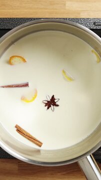 Hands place saucepan with prepared mixture on stove. Custard temperature control helps dairy thicken slowly without boiling. Gentle heat prevents lumps, burnt flavour and curdling in pastry class.