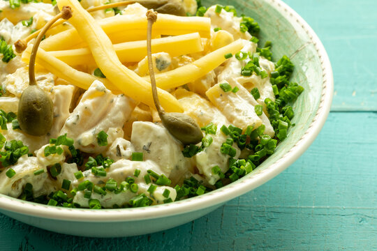 Potato salad with a twist: replace pickled cucumber with fermented yellow snap beans and top with caper berries.