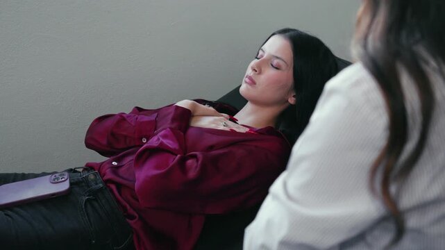 Young woman undergoing hypnotherapy session with a psychologist