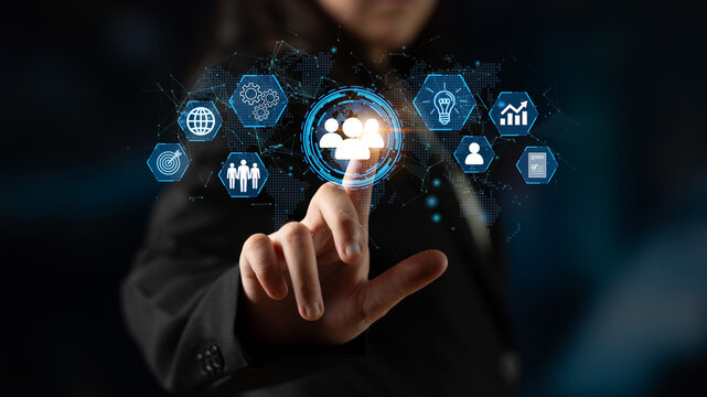 A business professional engages with digital icons representing technology and innovation, highlighting modern interaction in a corporate environment. Entropy.