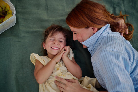 Mother and daughter laughing enjoying picnic outdoors