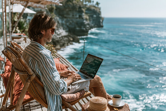Digital Nomad Working on Laptop Overlooking Ocean