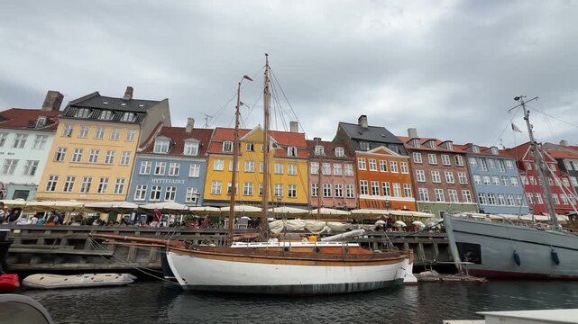 Historic wooden boats docked at Nyhavn harbor in Copenhagen, Denmark