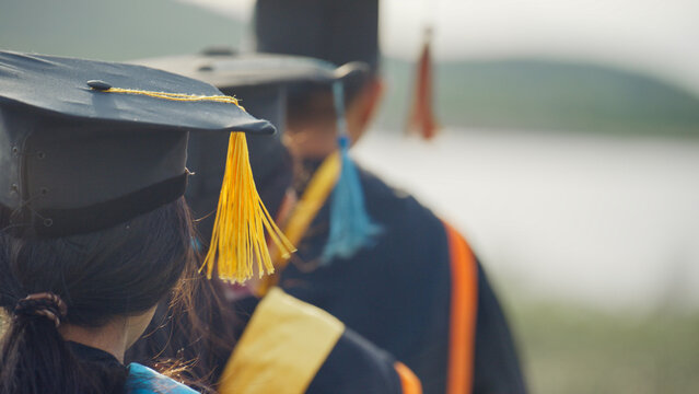 Graduates Wearing Academic Caps and Gowns at Outdoor Graduation Ceremony