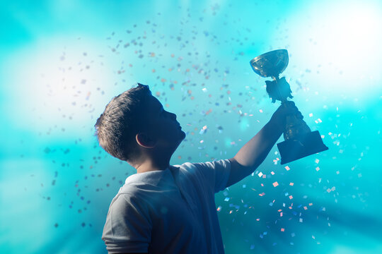 Silhouette of Boy Raising Trophy Amid Falling Confetti