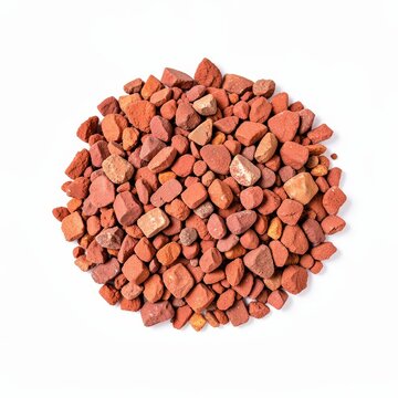 Angular crushed decomposed granite mulch piece in dusty red tone isolated on white background for landscaping and garden design