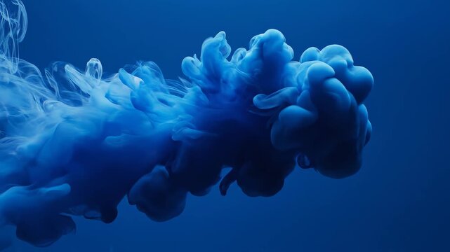 Blue ink cloud expanding slowly in dark water with cinematic motion and selective focus