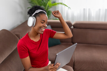 Young woman enjoying music and video on tablet with headphones at home © ivanko80