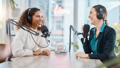 Fototapeta na wymiar Two happy women record a lively podcast in a modern studio. Their joyful laughter creates an inviting atmosphere of professional collaboration, authentic connection, and engaging media production.