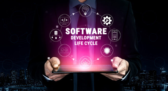 Professional Man Holding Tablet with Graphics Illustrating Software Development Life Cycle in a Modern Business Environment at Night Quark.