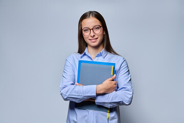 Obraz premium Young female student holding notebook folder standing looking at camera studio